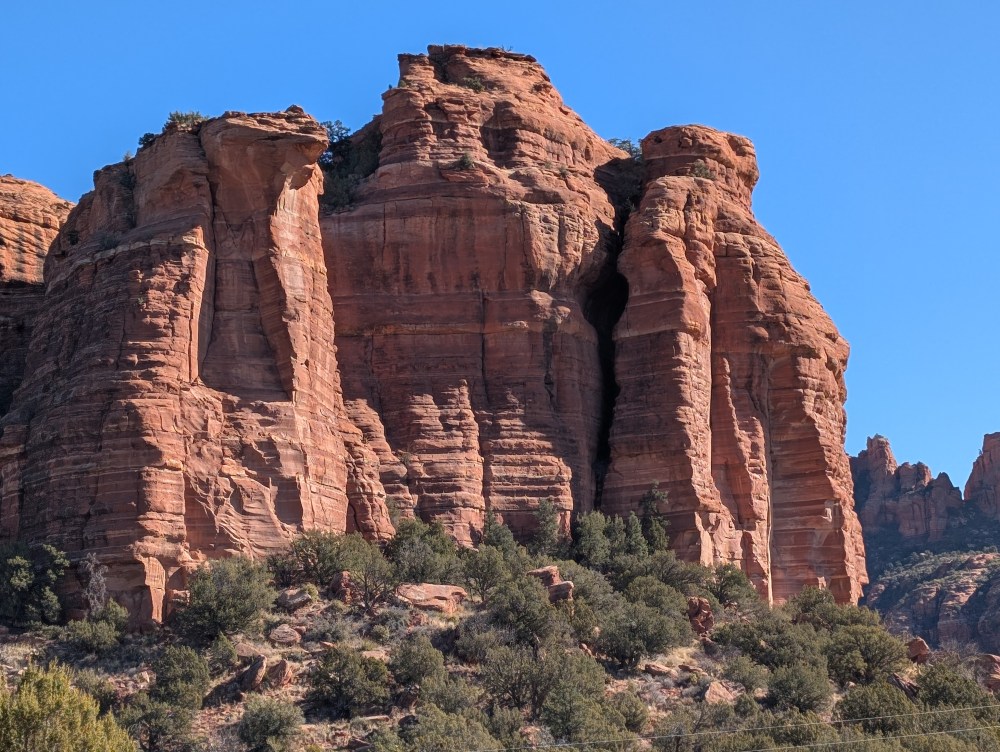 Sunlight filters through the towering cliffs, casting warm shadows over the undulating terrain.  The scene exudes a sense of exploration and discovery, with the magnificent natural beauty of Sedona serving as the perfect backdrop for an unforgettable off-road excursion.